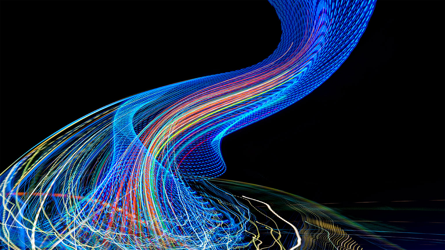 Light rails emerge from a complex tangled web to a structured flow in an image about chaos, organization and management.