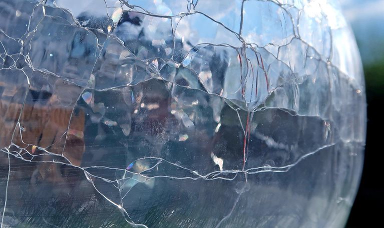 Cracked glass vase. Refracted, reflected and distorted light. Abstract background