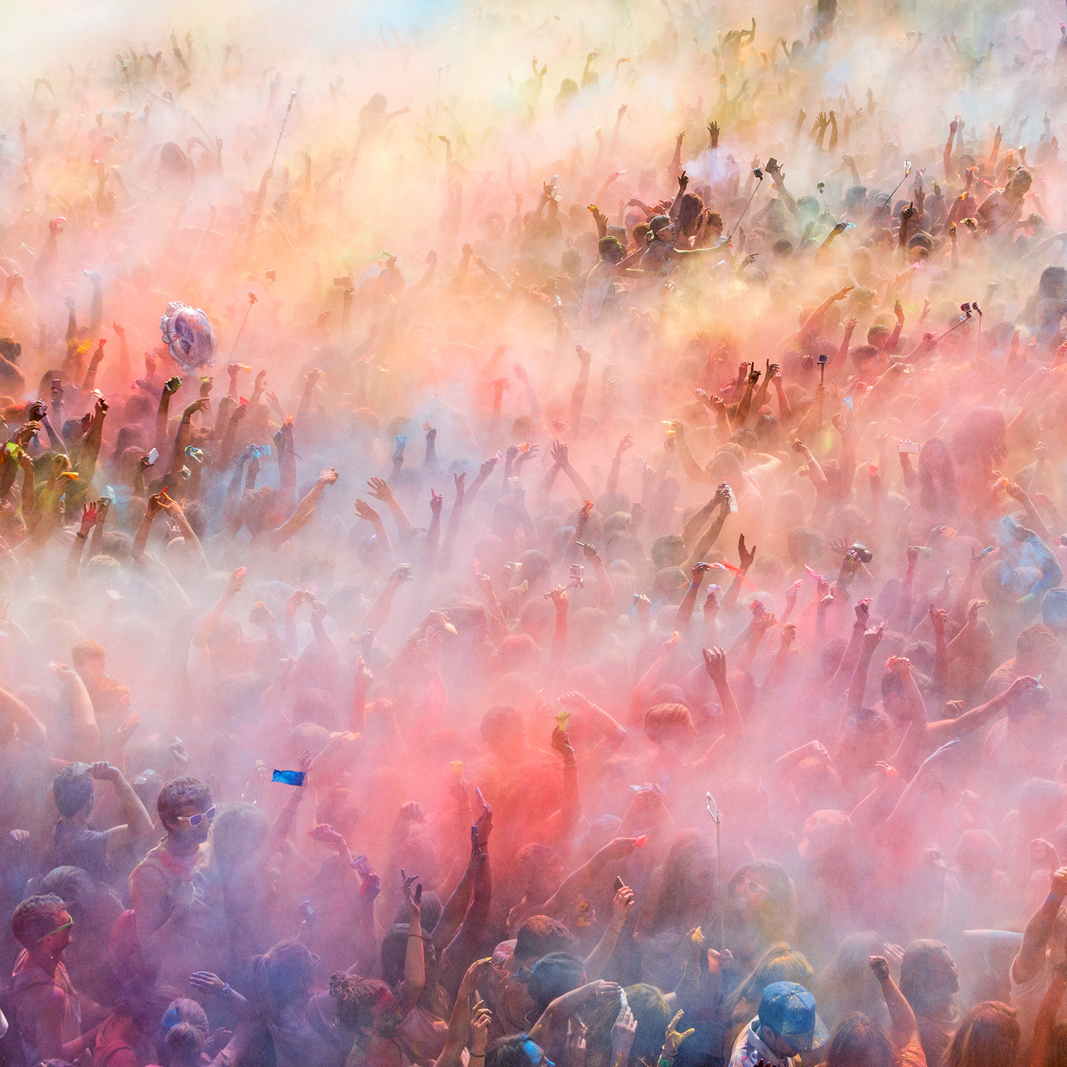 People throwing colored powders and dancing during the celebration of the Holi festival