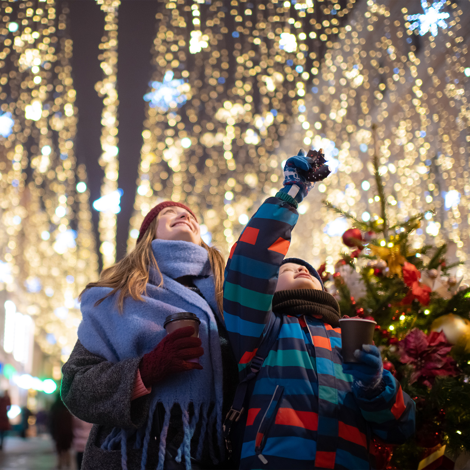 Little boy with his mother buying tera and sweets at a Christmas market.