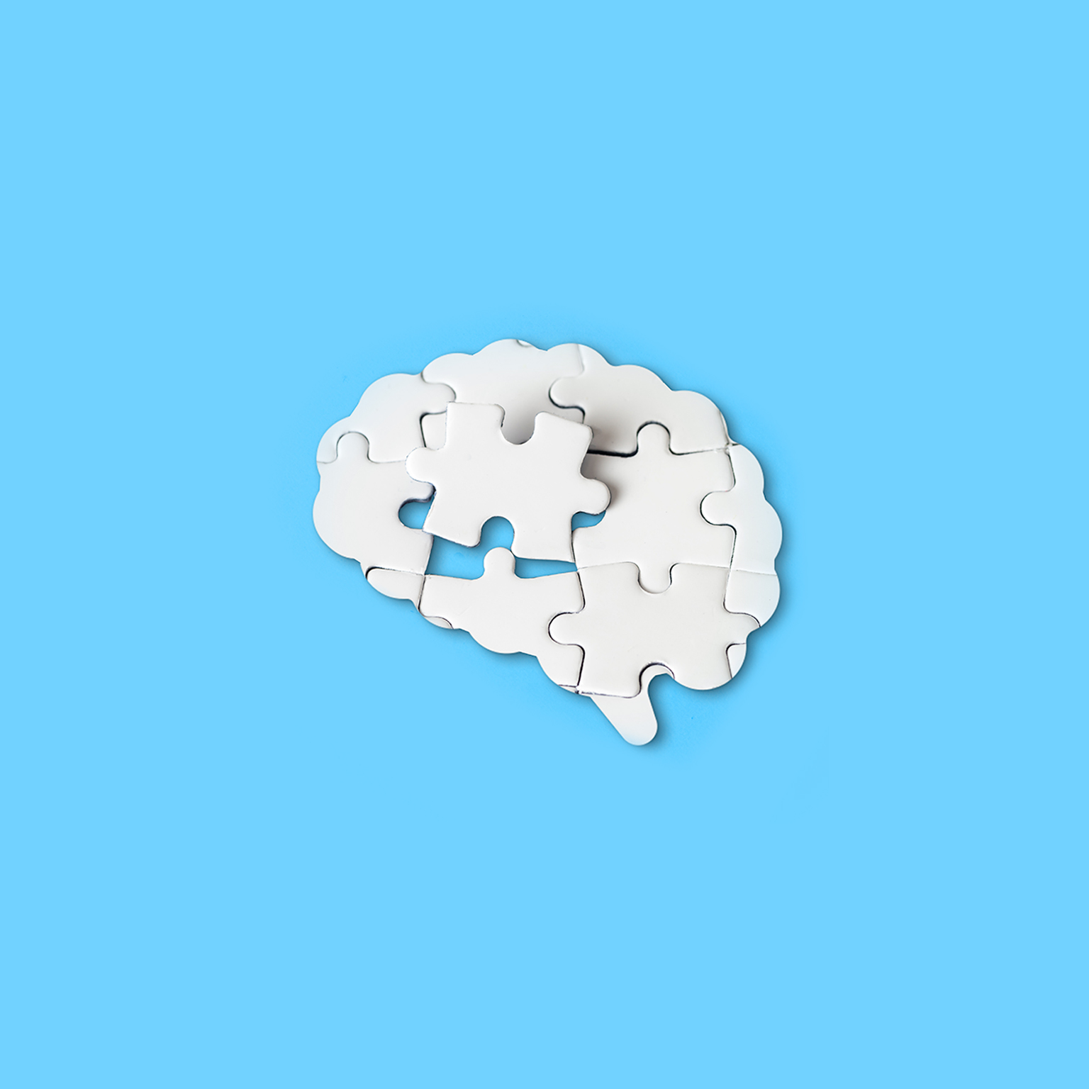 Missing piece in the brain shaped jigsaw puzzle fits into place. - stock photo