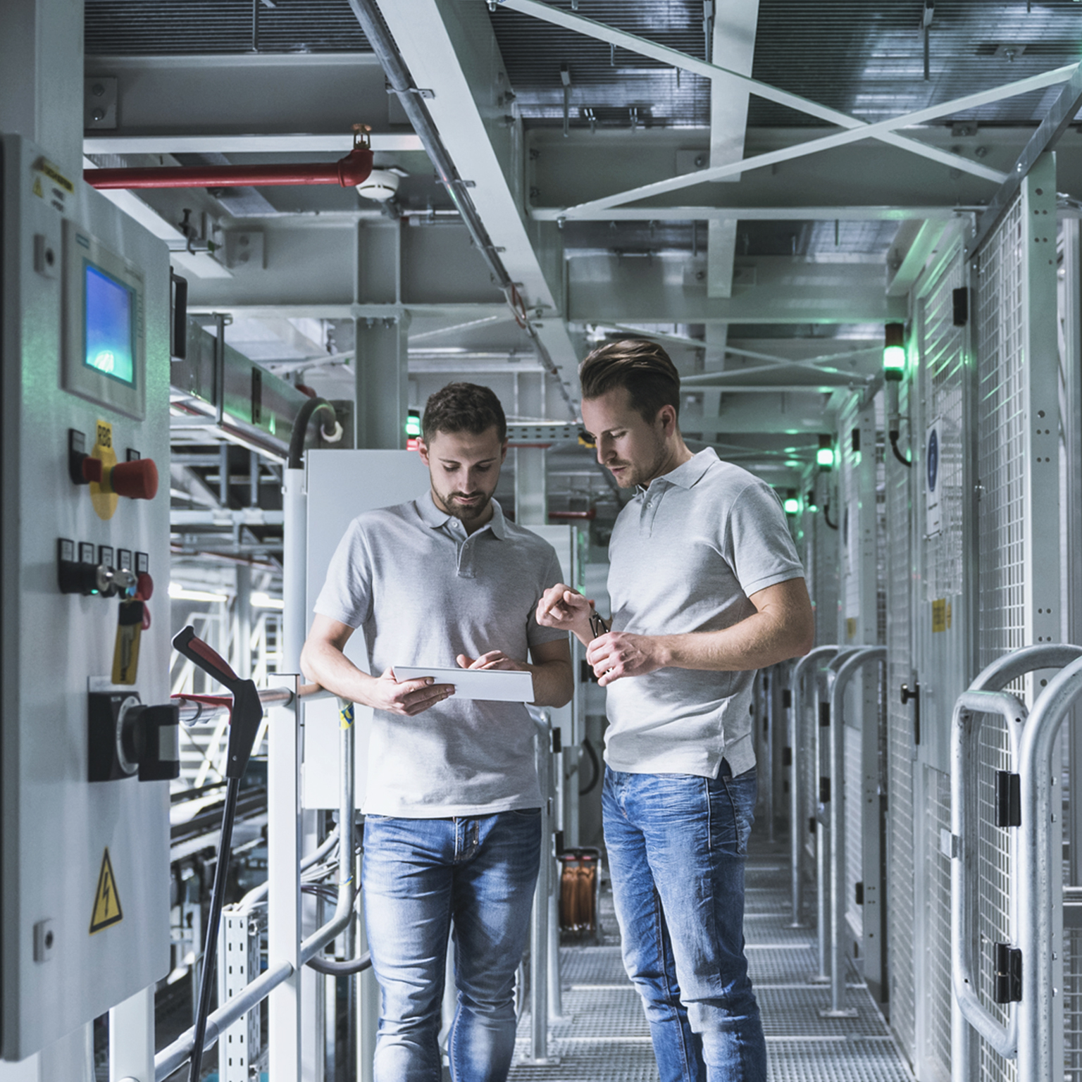 Two men in automatized high rack warehouse looking at tablet