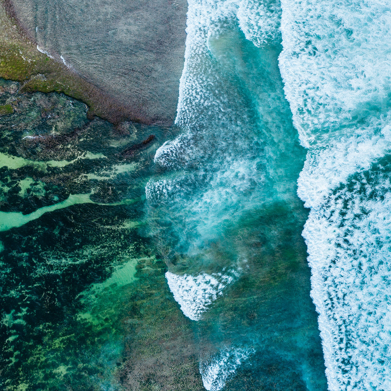 Big ocean waves hitting a coral reef. View from above. - stock photo