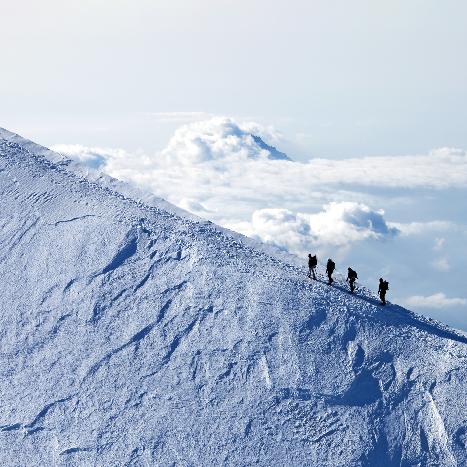 Climbers ascending on a snow mountain peak