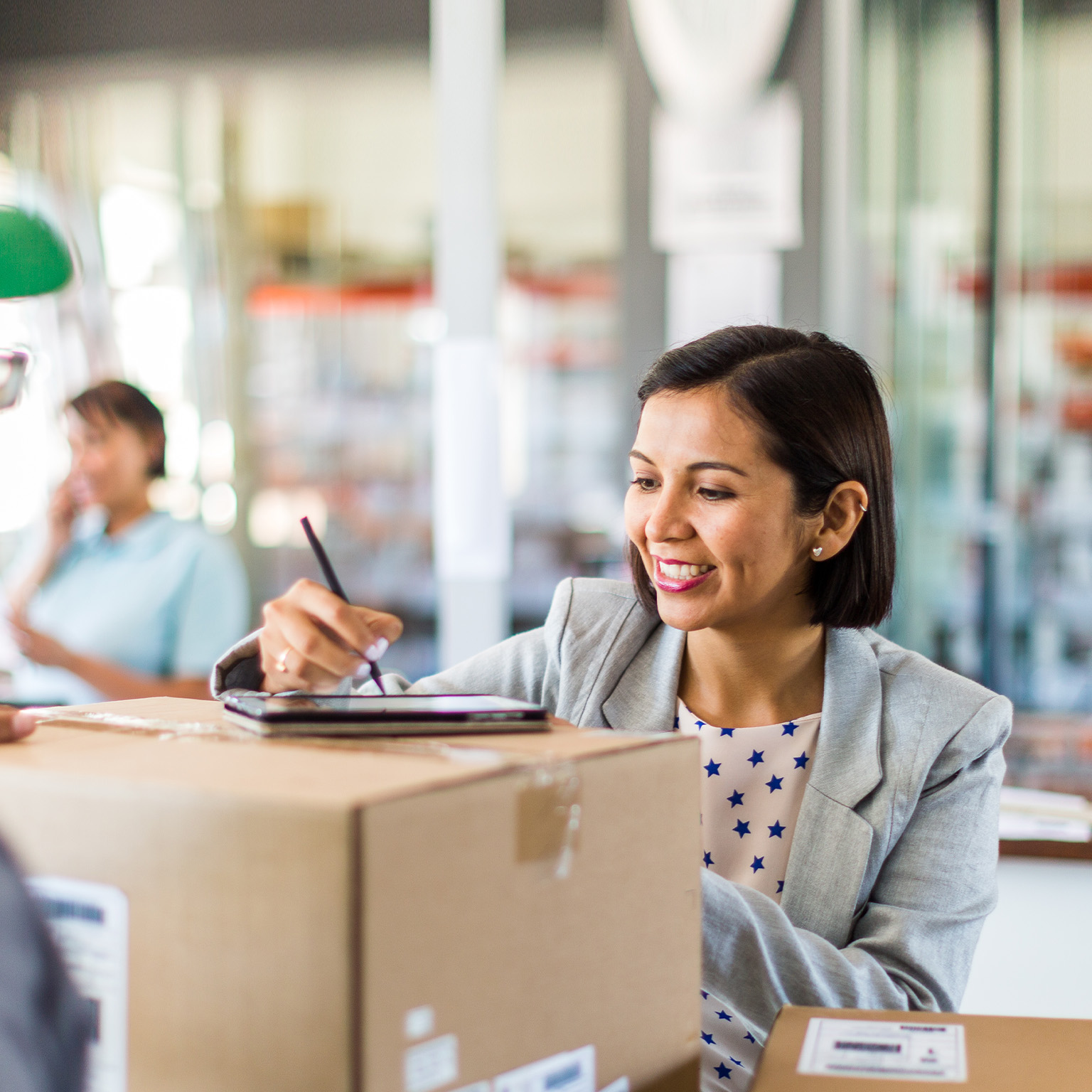 Courier collecting or delivering parcels from small business - stock photo