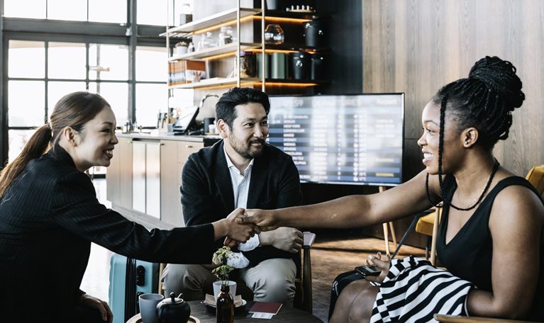 Three people greeting each other