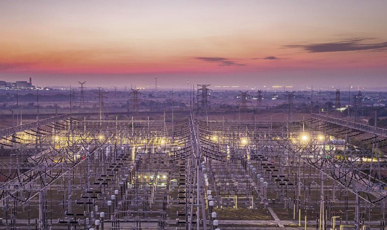 Big city, transmission towers at sunset