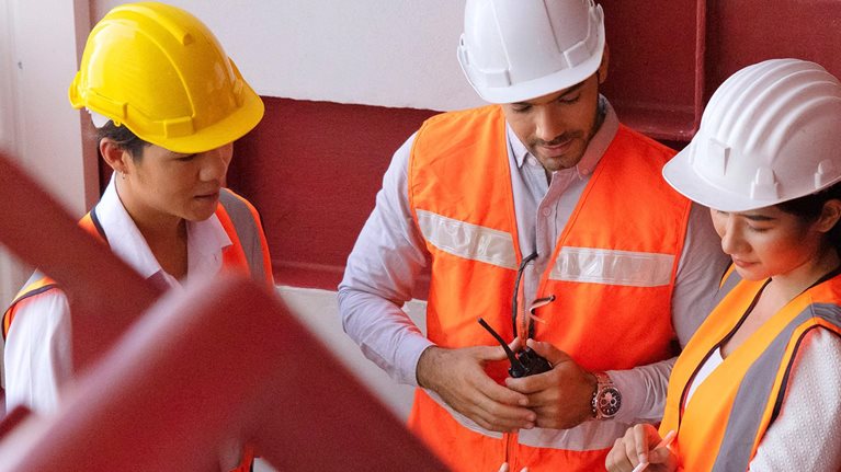 photo construction workers gathered around tablet