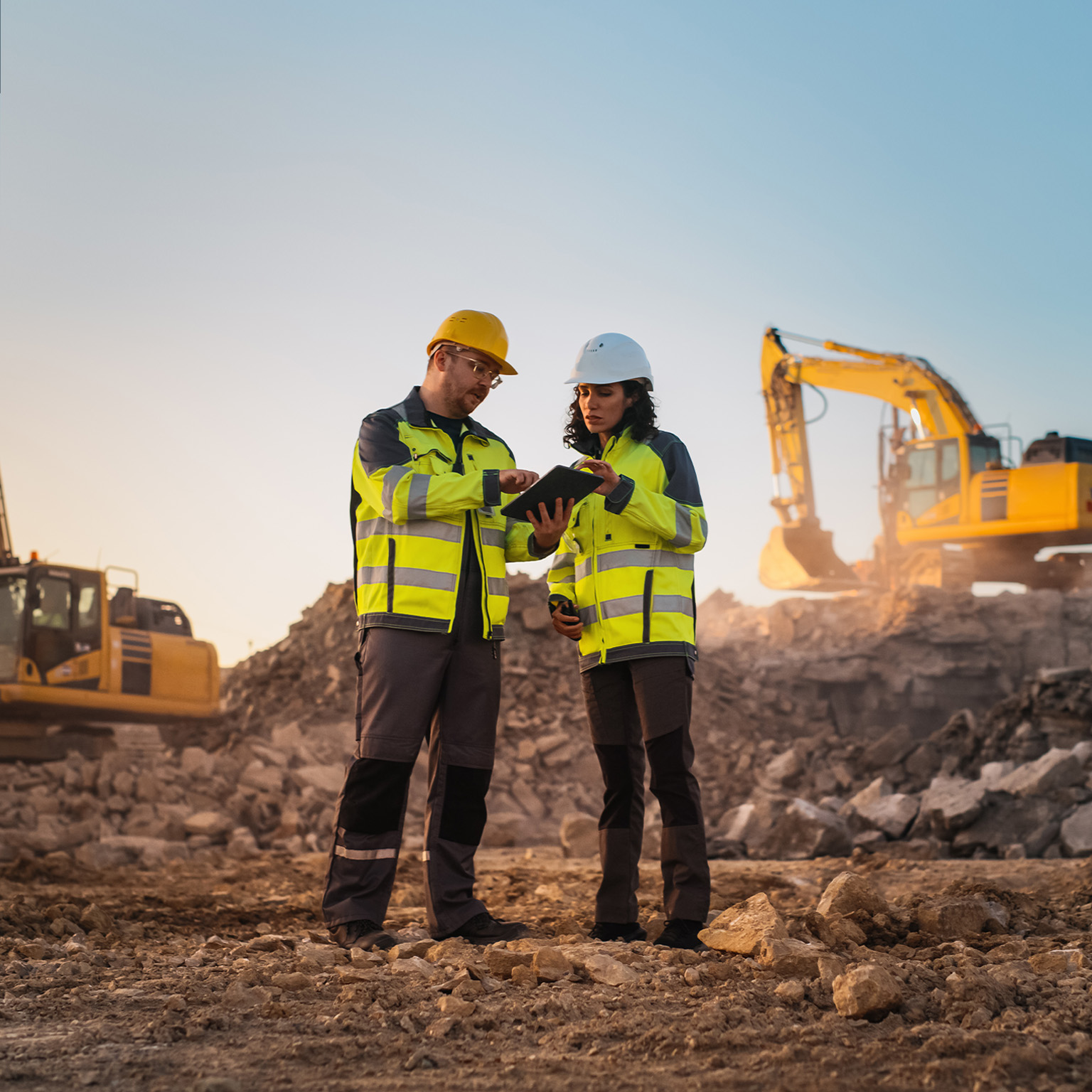 Using Tablet On Construction Site of New Apartment Complex. Real Estate Developers Discussing Business, Excavators Working.