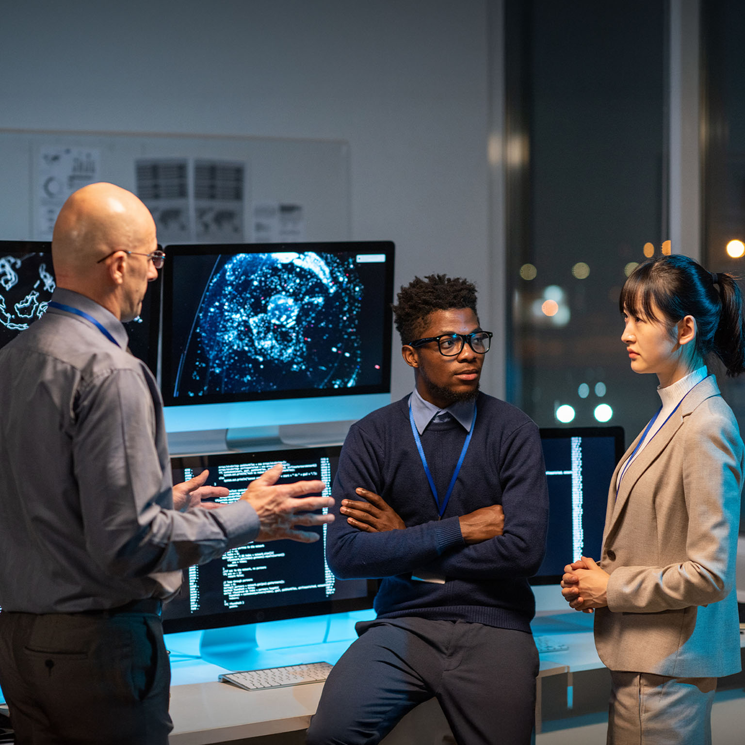 Three intercultural colleagues in formalwear discussing working points at meeting