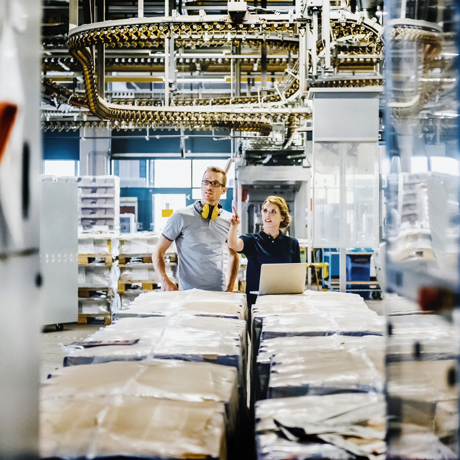 Engineers working on laptop in a large printer