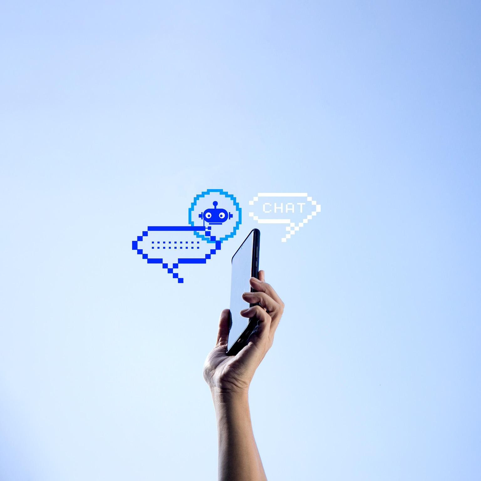 A hand holding a mobile phone with two pixelated chat bubbles and an AI bot icon against a clear blue sky.