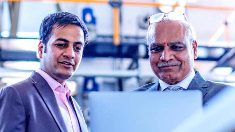 Two men looking at a laptop screen