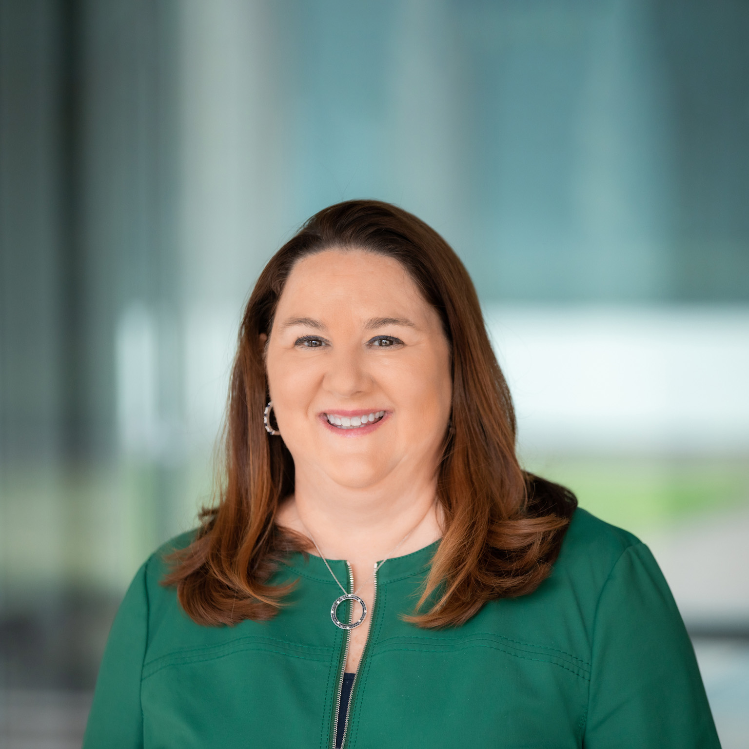 Lisa Blair Davis wearing a green business jacket and a smile on her face.