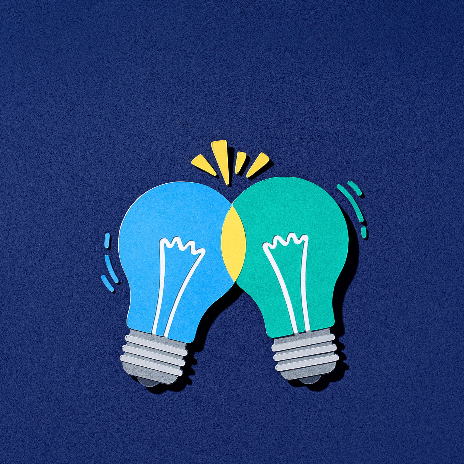 Paper-cut illustration of two lightbulbs intersecting