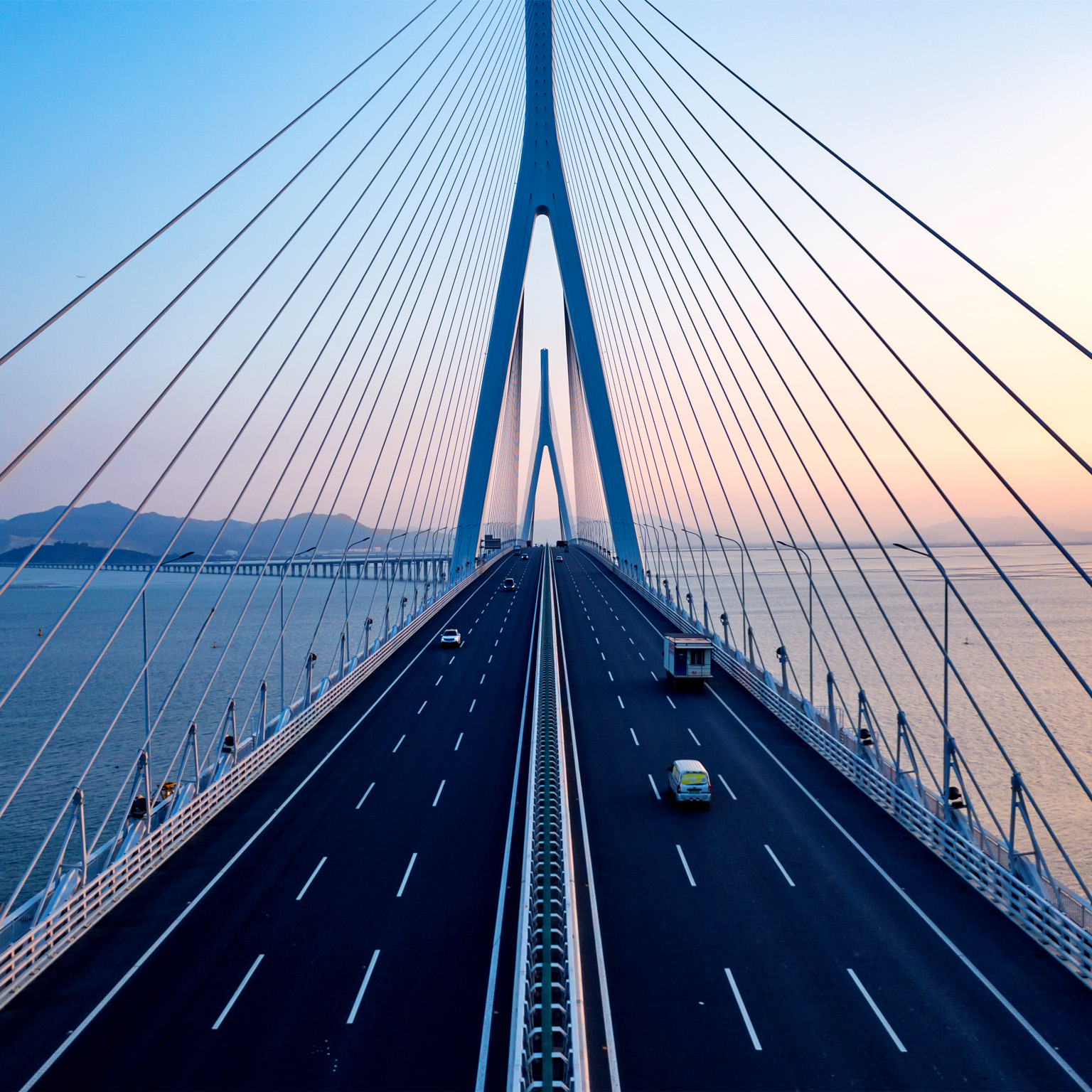 Aerial view of a bridge across a bay at sunset.