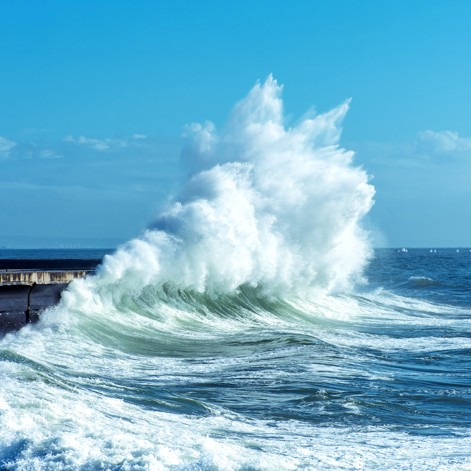 Big waves breaking against a seawall on the coast