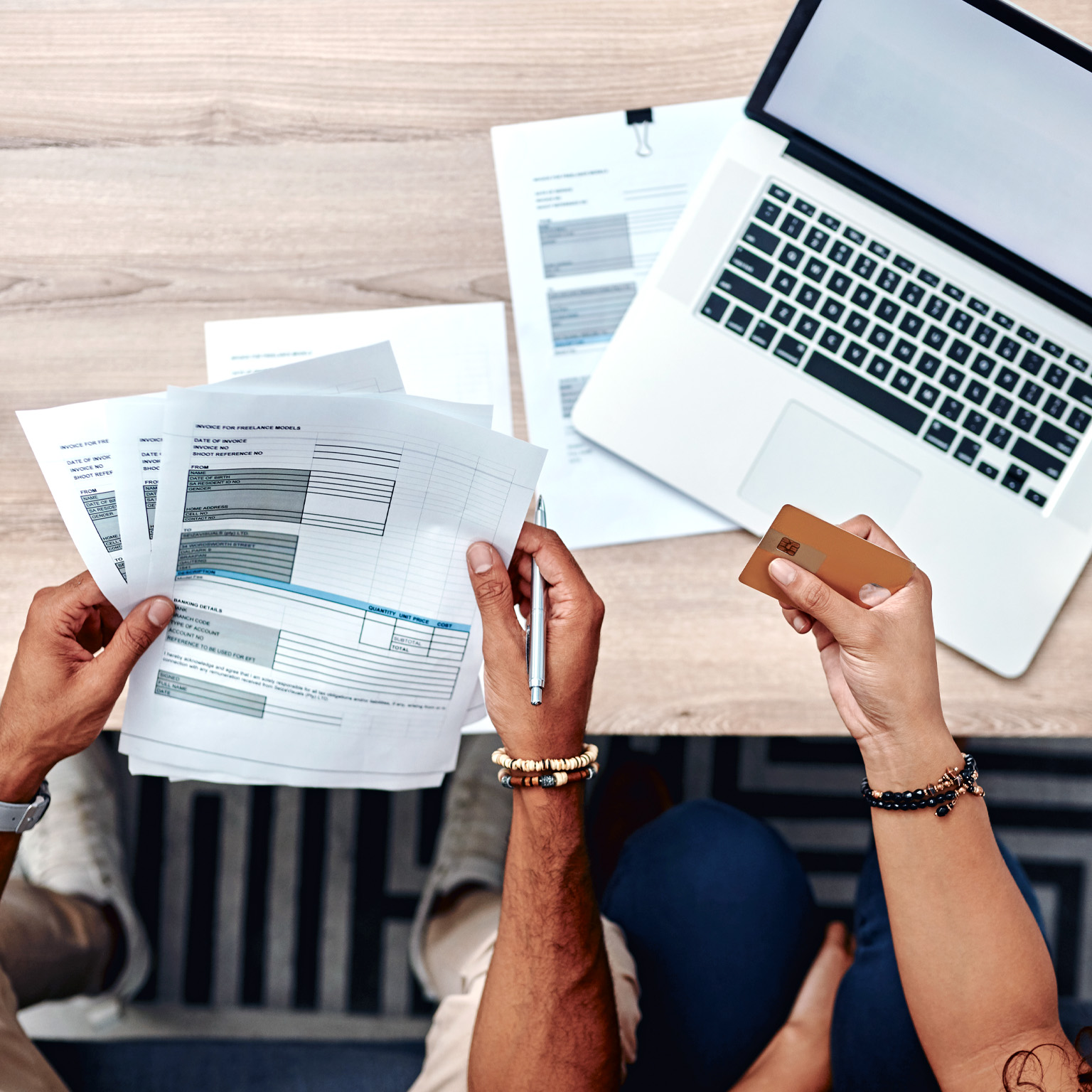 High-angle shot of a young using a credit card while going over their finances at home
