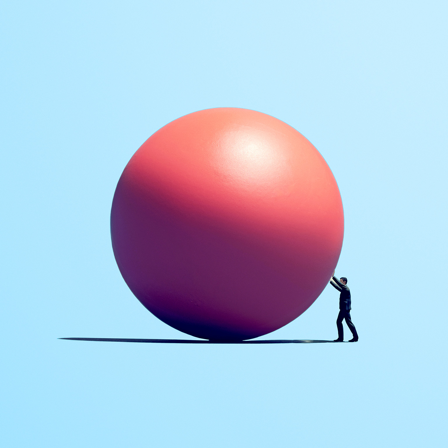 Person pushing a large pink sphere across a flat surface against a light blue background.