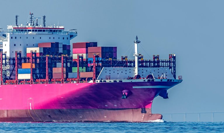 A Pink Container Ship is Sailing on the Sea