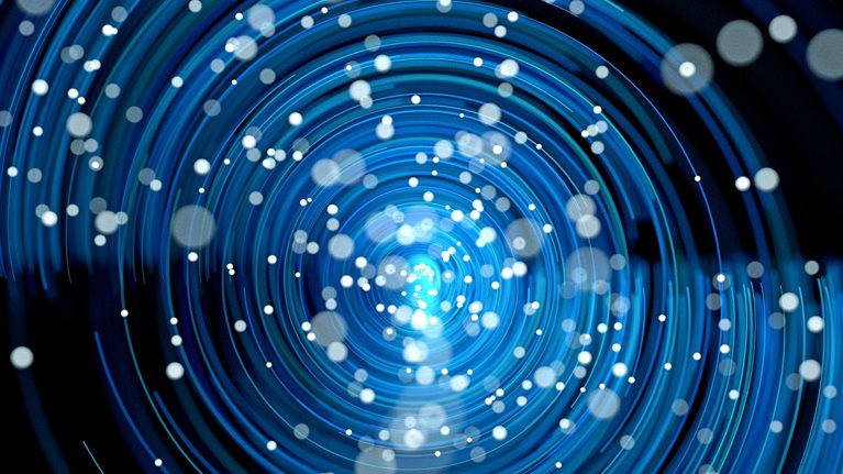 A dynamic, abstract pattern of glowing blue concentric rings spiraling toward a bright center. Small white dots are scattered throughout, resembling particles or stars moving through a vortex-like field.