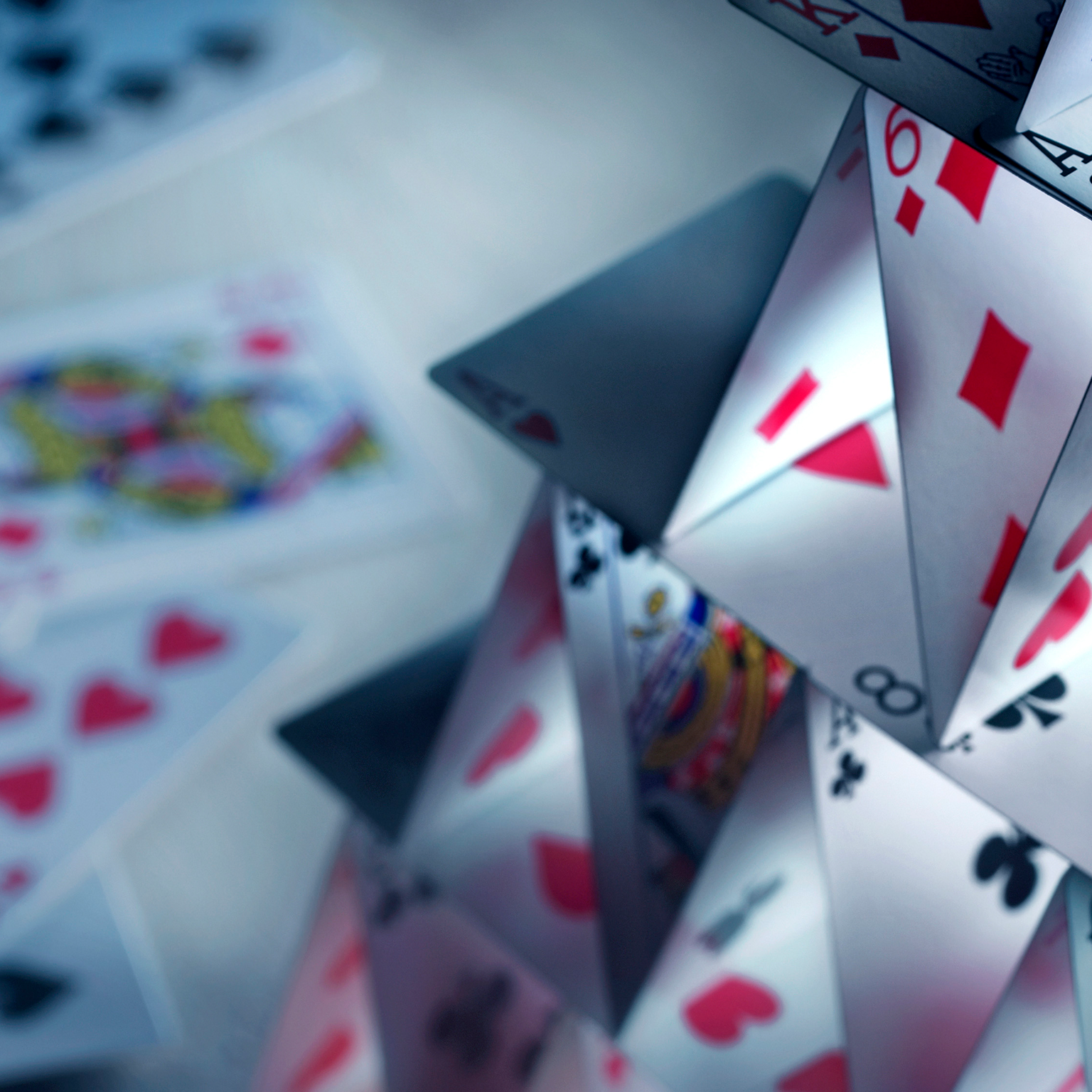 A house of cards built with a variety of playing cards.