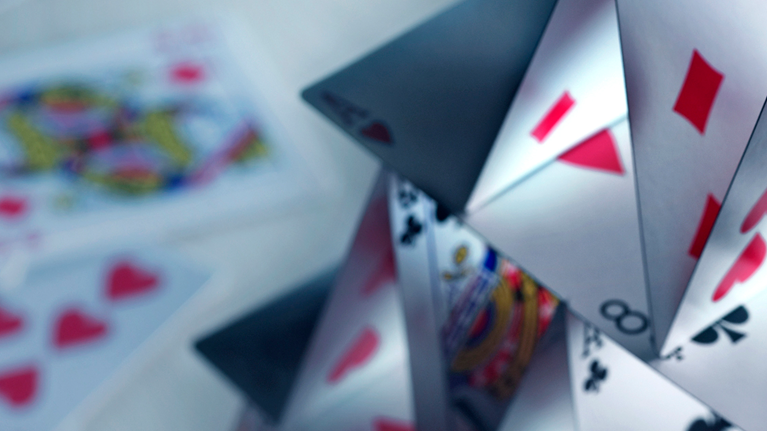 A house of cards built with a variety of playing cards.