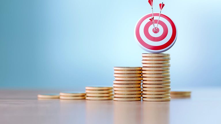 Red dartboard and arrows sitting before defocused background