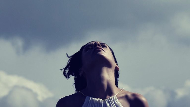 Photo of a woman inhaling outdoors without a face covering