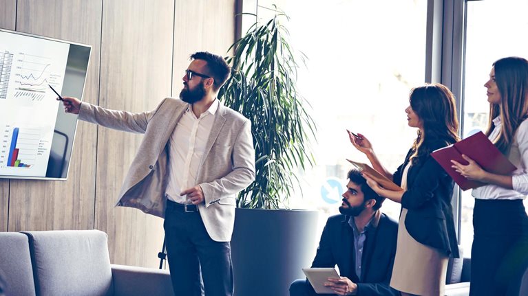 Corporate team engaged in a productive business meeting, with the Chief of Staff delivering a presentation in a contemporary office setting.