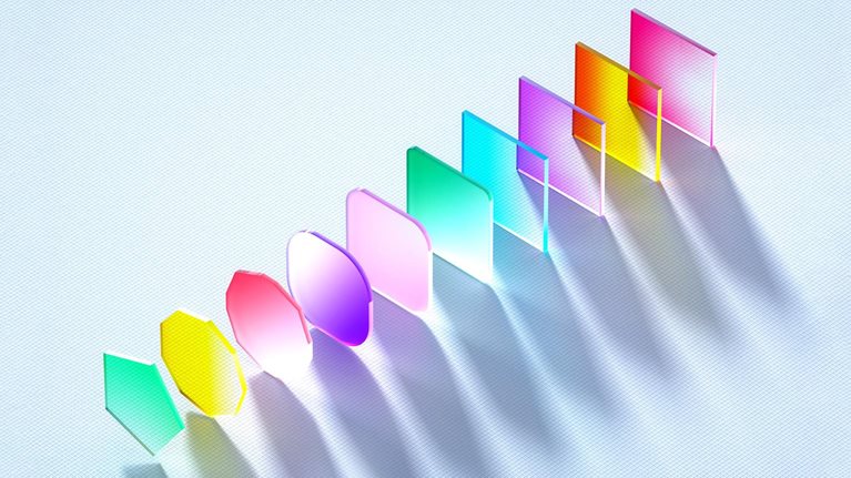 An abstract image of differently shaped and colored glass panes lined up diagonally with light being cast across them.