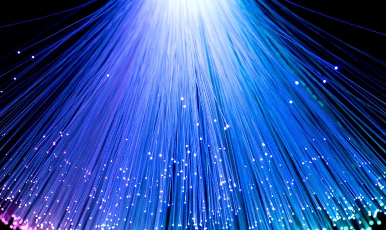 Multi-colored converging fan shape fiber optics on black background.