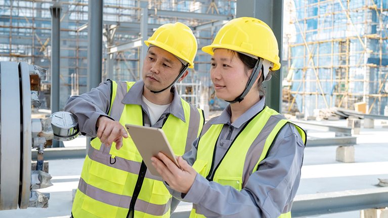 Two male and female engineers are checking equipment in the chemical plant - stock photo
