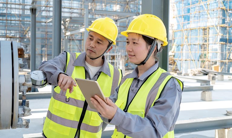Two male and female engineers are checking equipment in the chemical plant - stock photo