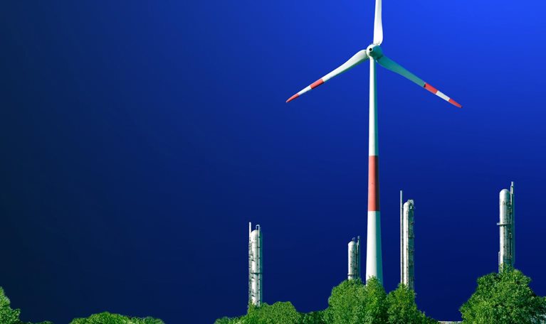 Wind turbine in front of a petrochemical installation