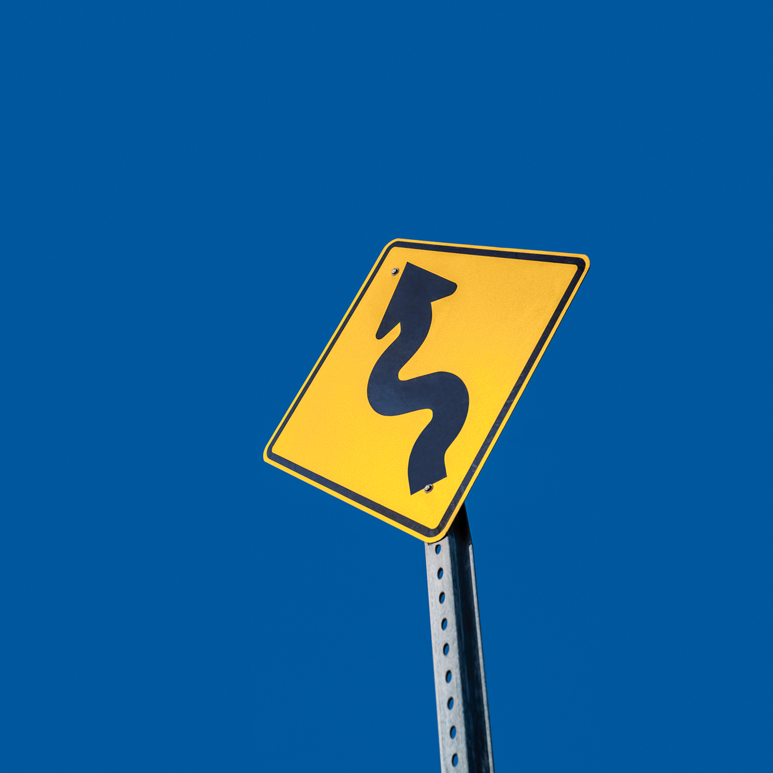 Winding road ahead warning sign