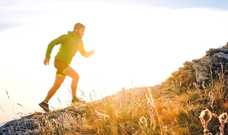 Italy, man running on mountain trail