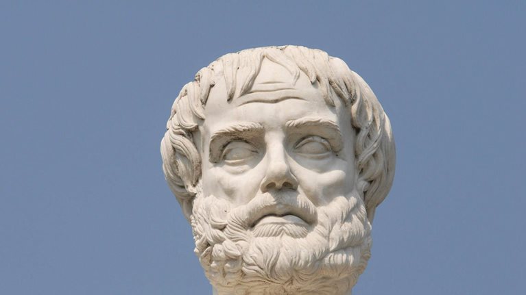 Close up view of white Greek statues head with a blue background.