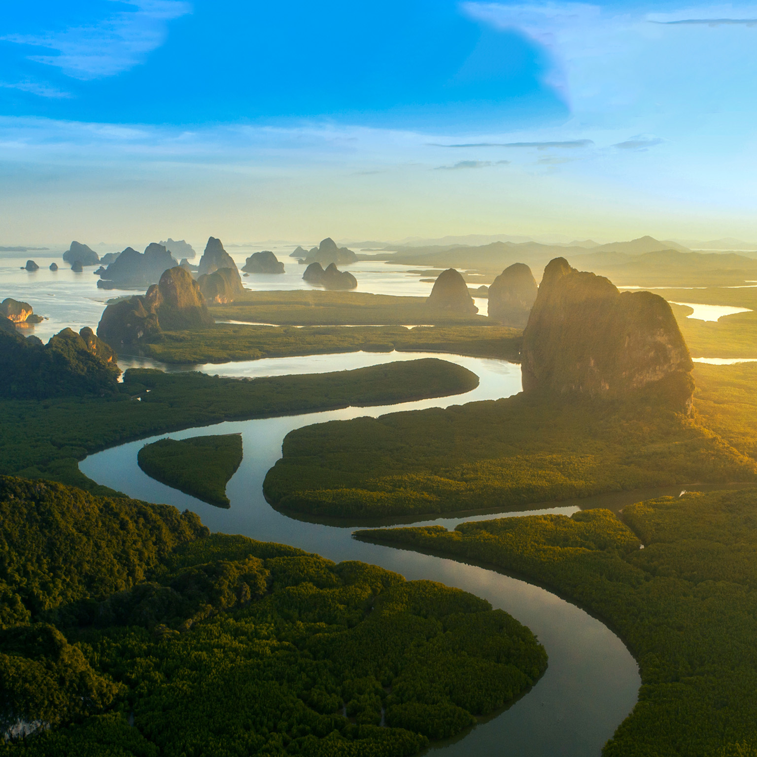 A horizon line view of the limestone cliffs and rock formations of Phang Nga Bay in Thailand.