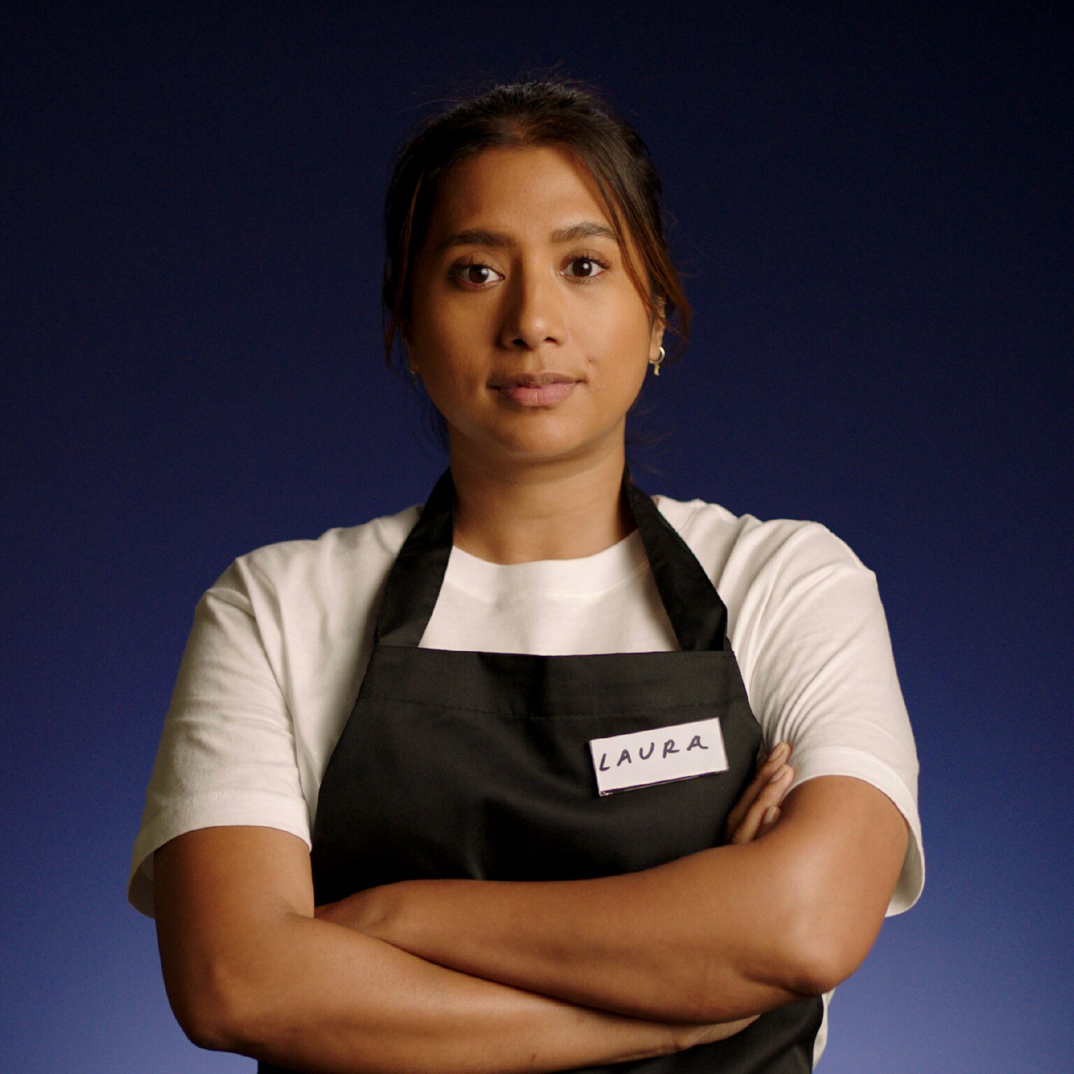 Frontline worker of color in an apron.