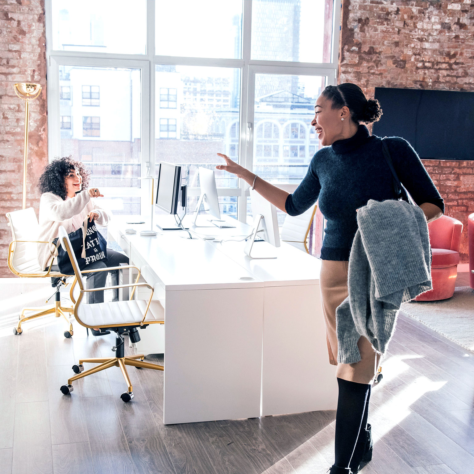 Woman waving goodbye to colleague in office