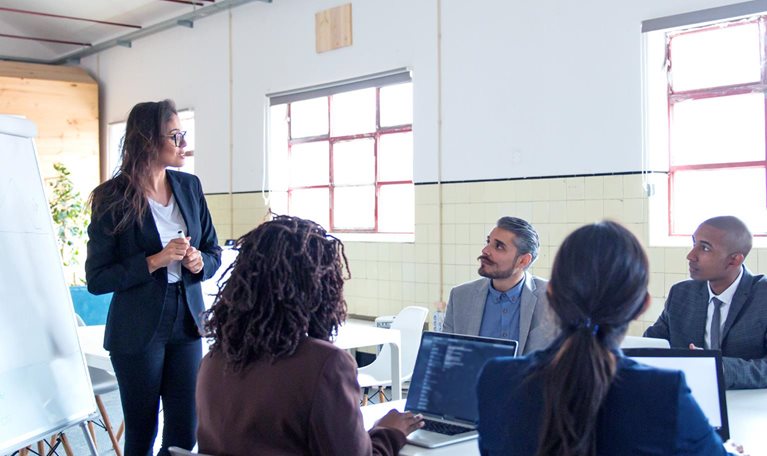 Confident female business trainer working with employees