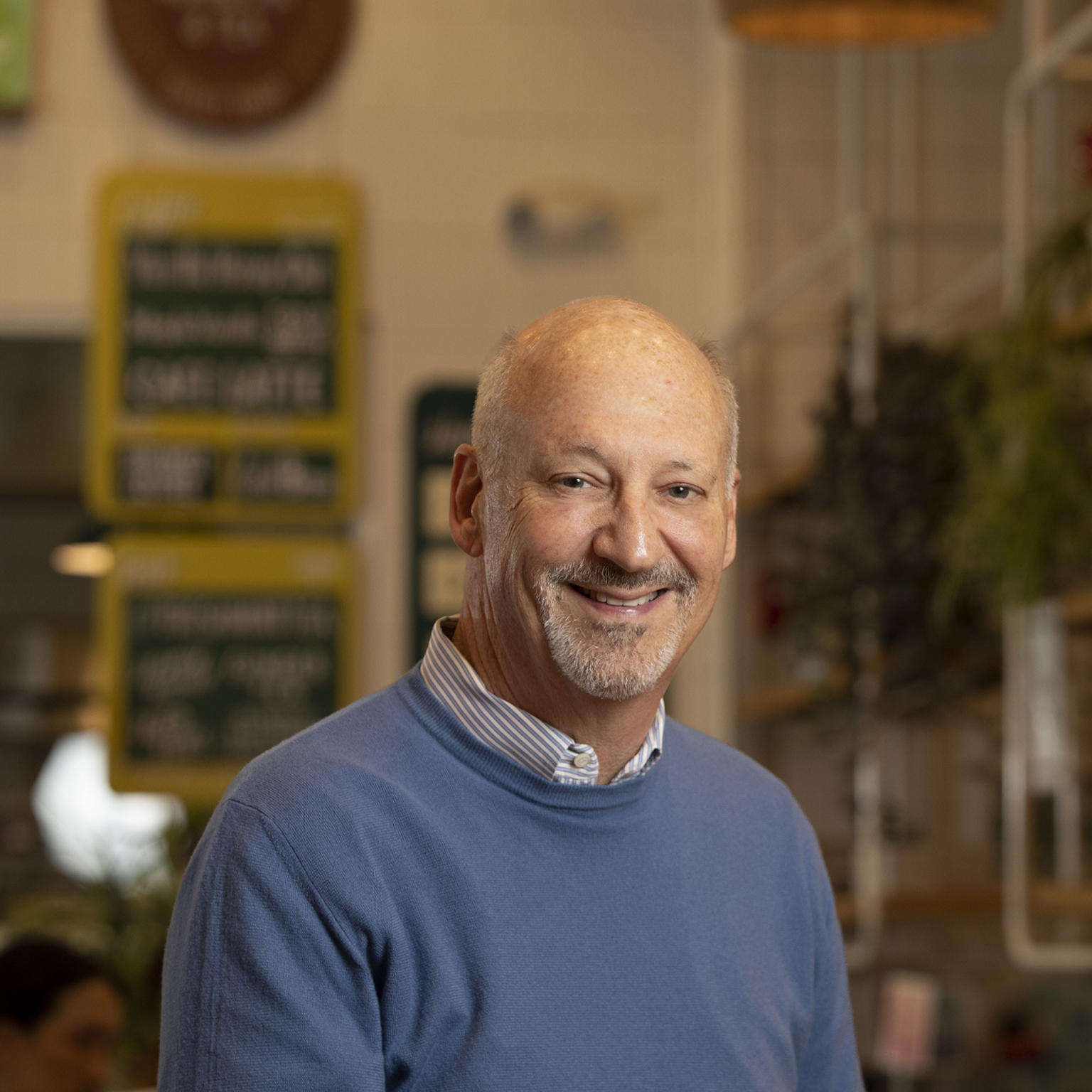 Portrait of Ron Shaich with a warm office setting blurred in the background.