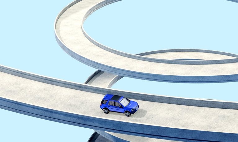A conceptual depiction of a blue vehicle traversing a lengthy, curving pathway in a spiral form. The backdrop is a uniform, pale blue hue.