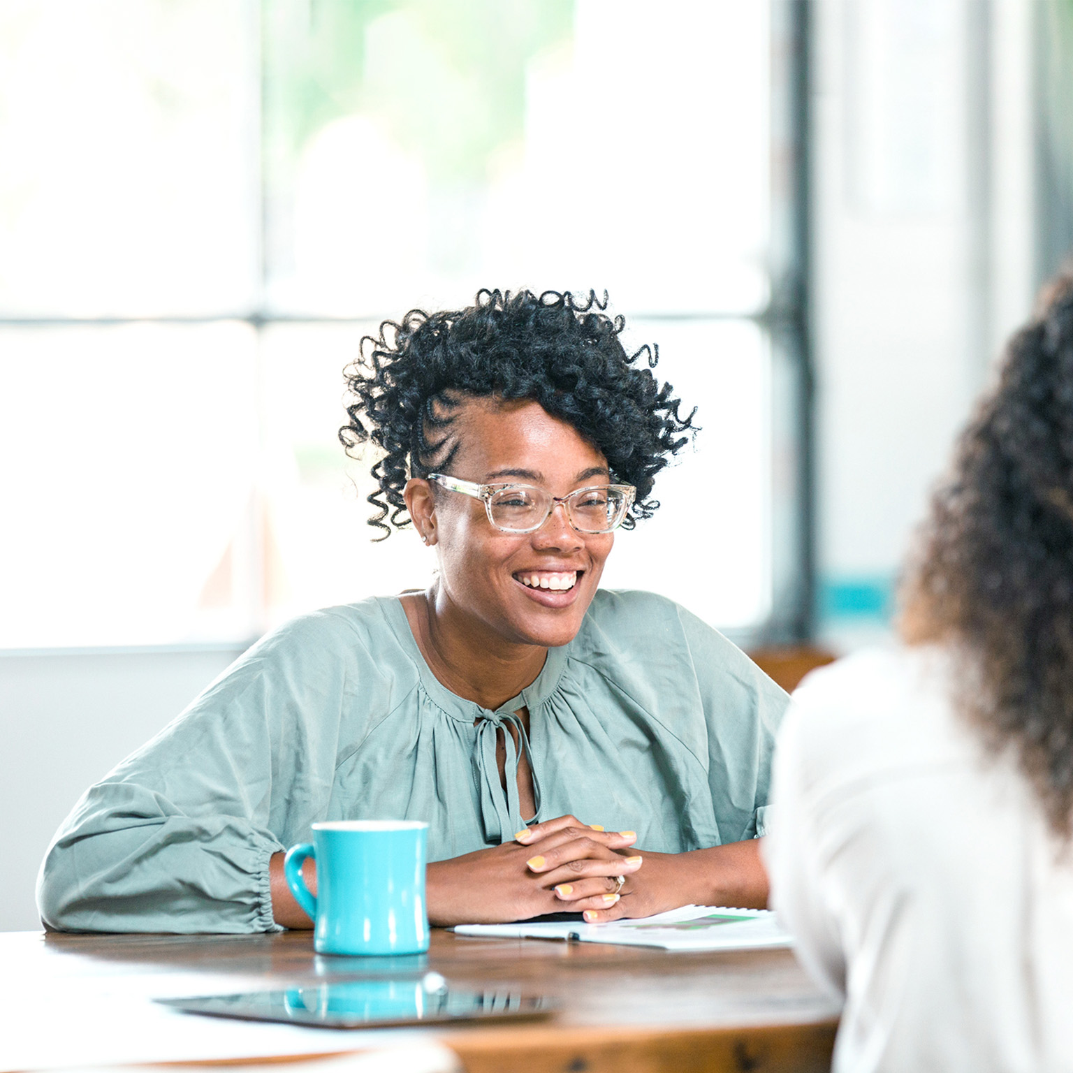 Cheerful woman meeting female friend for coffee