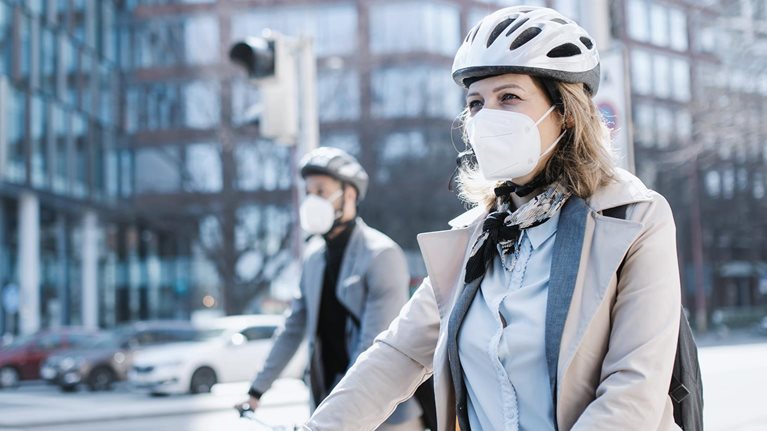 Businesspeople commuters wearing face masks with electric scooter and bicycle in city, crossing the road.