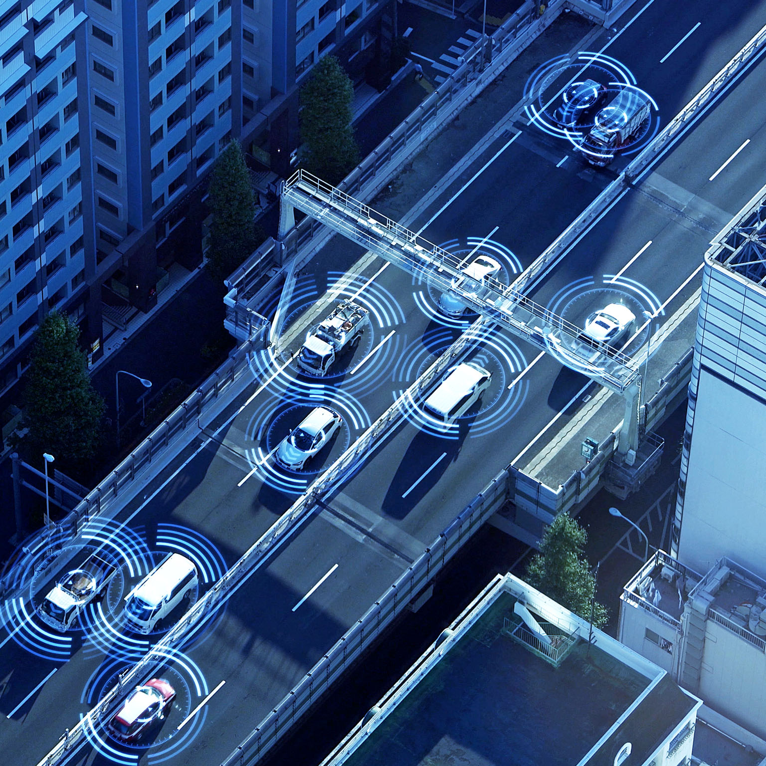 Aerial view of a multi-lane urban highway with illustrated digital sensor overlays on each vehicle.