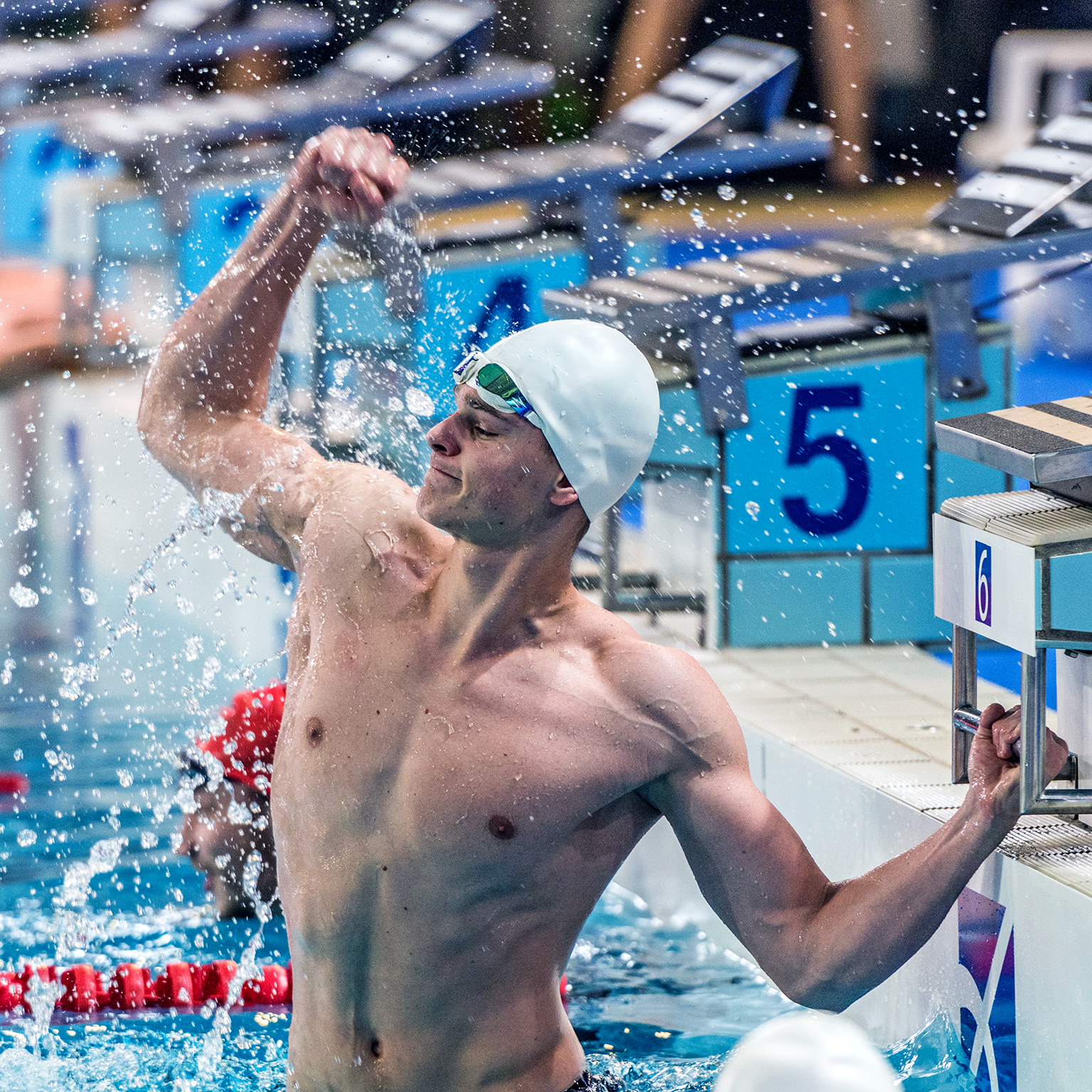 Male swimmer punching the air during swimming competition.