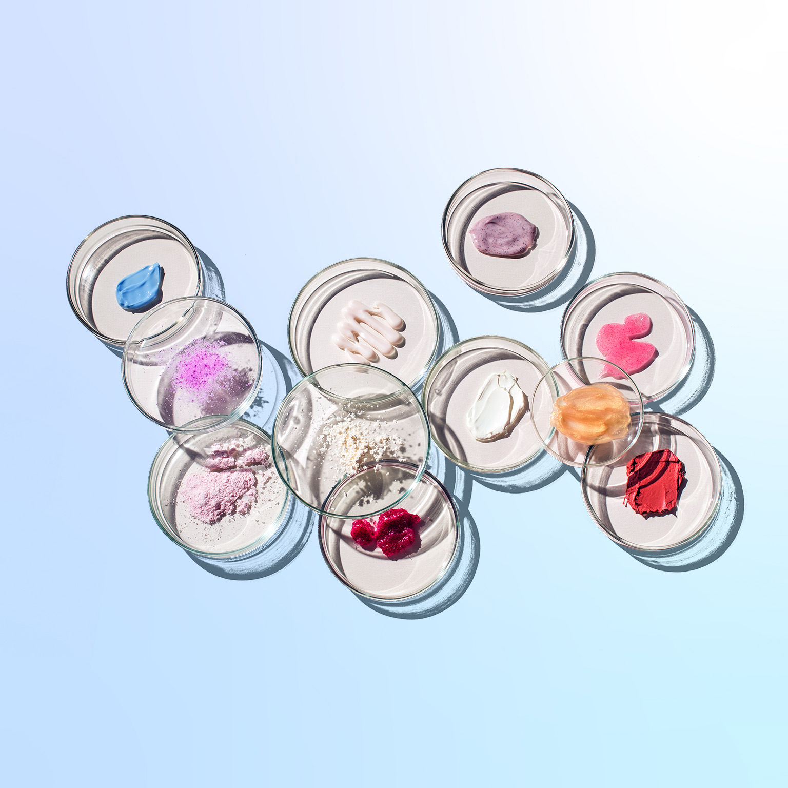 Top view of numerous petri dishes with various cosmetics in them.