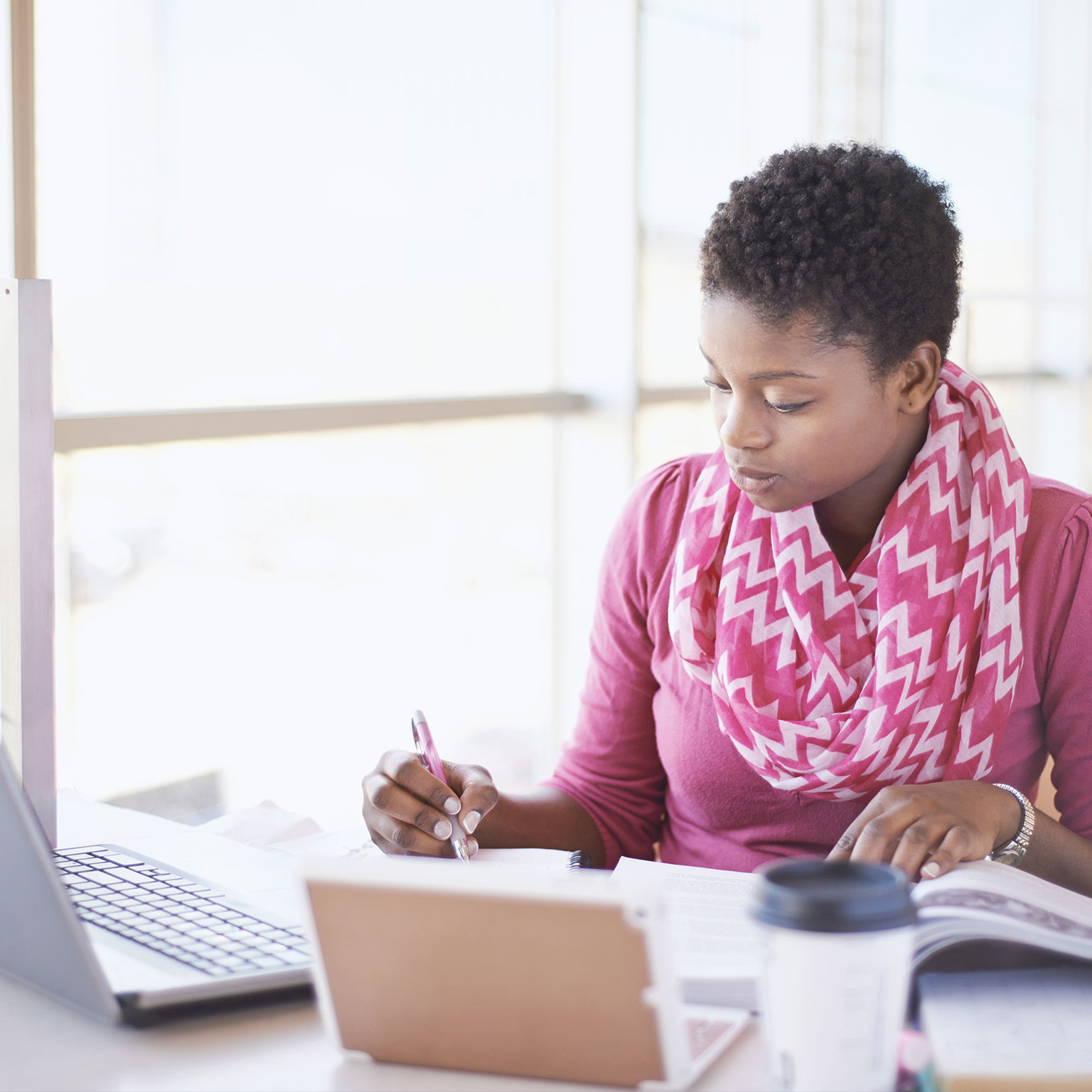photo woman with open book taking online course on laptop